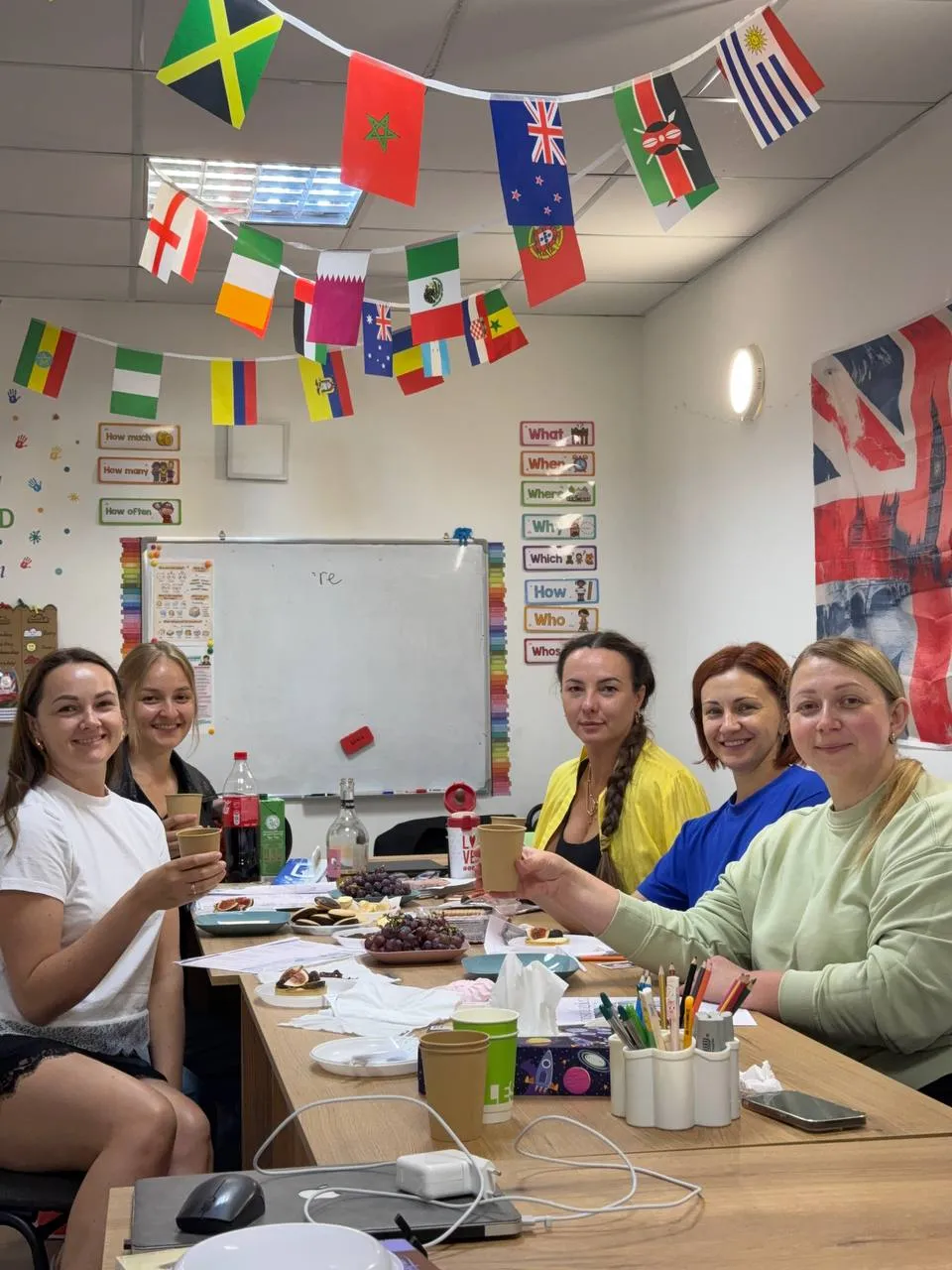 Дорослі в класі Slay School під гірляндою з прапорів різних країн